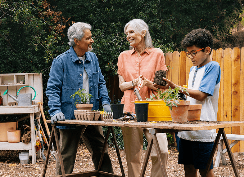 Man, woman, and young boy gardening in a backyard