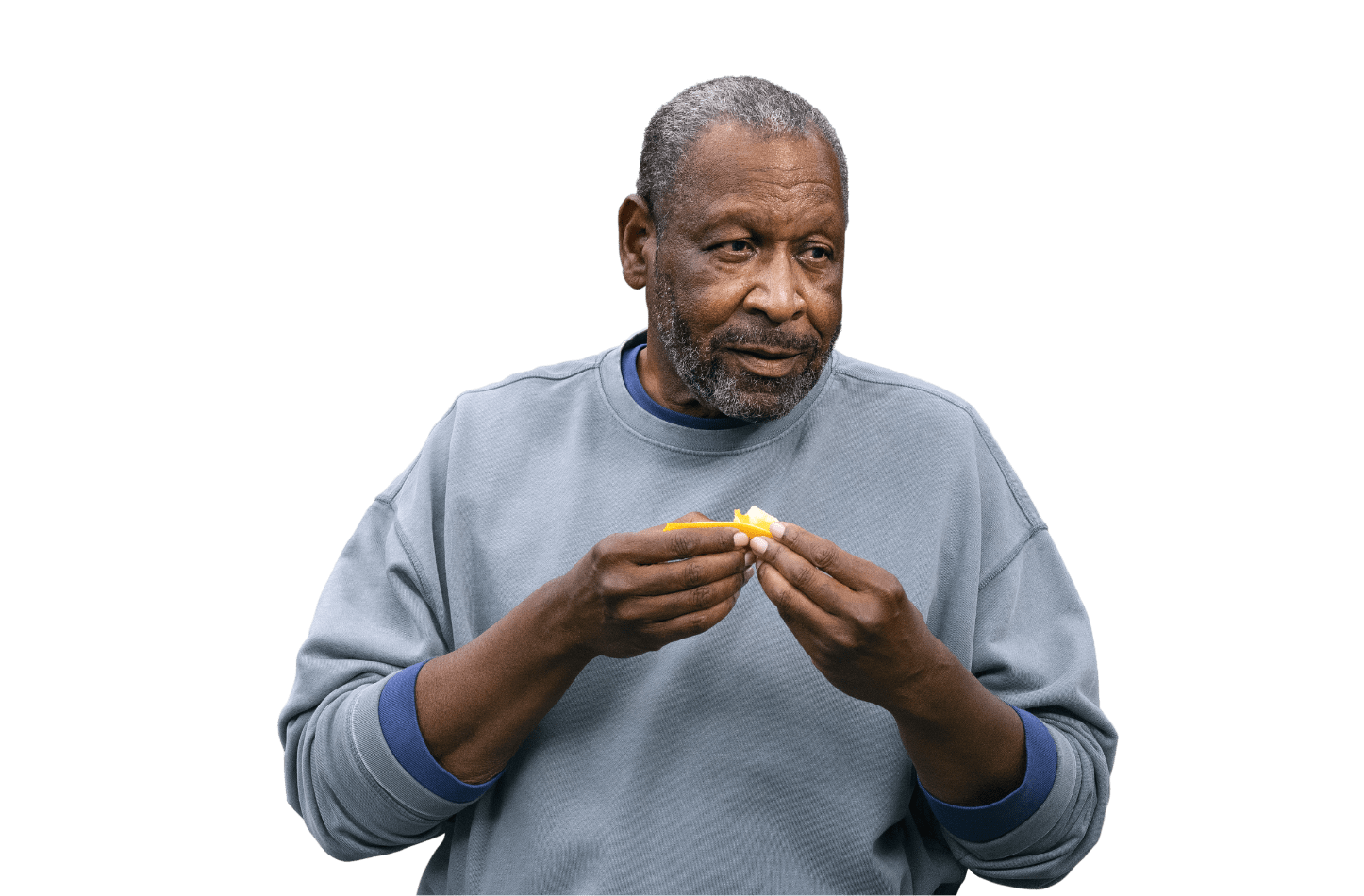 Man in blue sweatshirt eating an orange