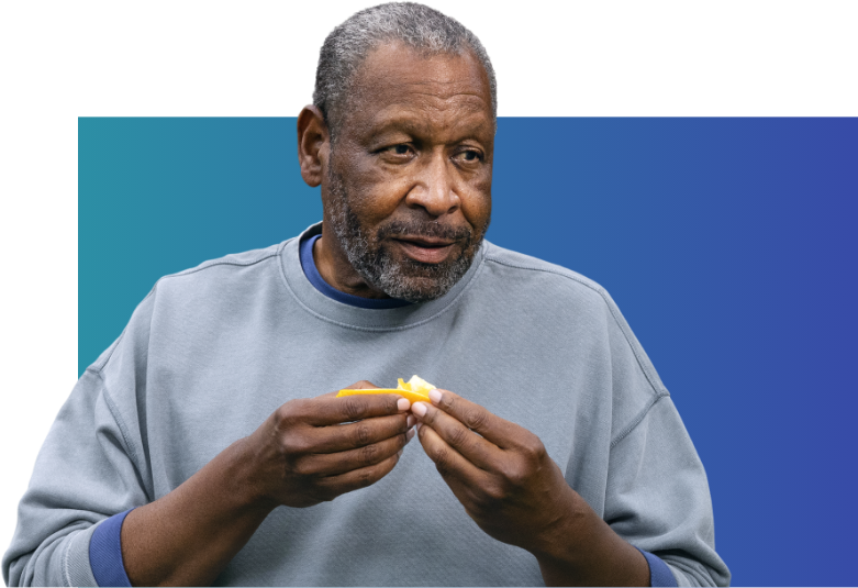 Man in blue sweatshirt eating an orange